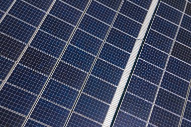 Solar çatılı ofis binası. Temiz ekolojik elektrik enerjisi üretmek için mavi fotovoltaik paneller. Yenilenebilir elektrik kavramına yatırım.