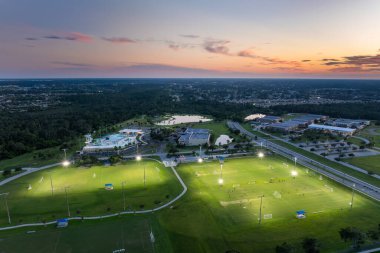 İnsanlar gün batımında halka açık stadyumda futbol oynuyorlar. Aktif yaşam konsepti.