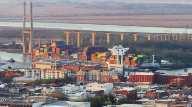 Gürcistan 'ın eski tarihi şehri Savannah' daki büyük konteyner gemisinin havadan görünüşü. Uluslararası üretim malları sevkiyatı. Günbatımında Güney Amerika mimarisi