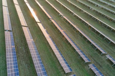 Temiz ekolojik elektrik enerjisi üretmek için sıra sıra güneş fotovoltaik panelleri olan sürdürülebilir büyük elektrik santralinin havadan görünüşü. Sıfır emisyon kavramı ile yenilenebilir elektrik.