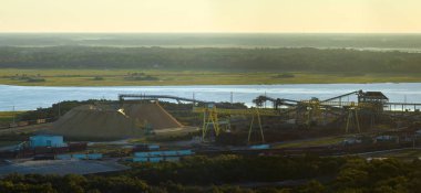 Aerial view of wood processing factory with smoke from production process polluting atmosphere at plant manufacturing yard. Industrial site at sunset. clipart