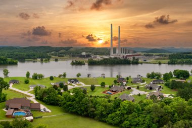 Fosil yakıtlardan elde edilen elektrik enerjisinden kaynaklanan hava kirliliği. Tennessee 'deki Kingston elektrik santrali yakınlarındaki yerel halk evleri. Elektrik üreten kömür santralinden zehirli emisyonlar.
