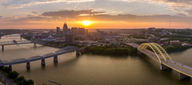 Cincinnati, Ohio 'da Daniel Carter Beard Köprüsü otoyolunda arabaları sürüyordu. ABD' nin şehir merkezindeki aydınlık gökdelen binaları yakınlarında. Gün batımında finans bölgesi olan Amerikan şehri.
