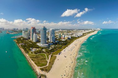 Güney Sahili 'nin kumlu yüzeyi. Sıcak Florida güneşinde dinlenen turistler. Güney Amerika 'da turizm altyapısı. Yüksek lüks otelleri ve apartmanları olan Miami Beach City..