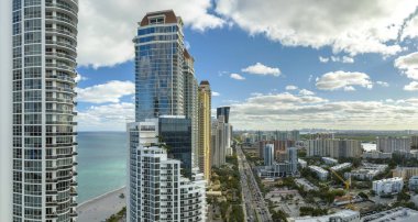 Sunny Isles Beach City 'deki Atlantik Okyanusu kıyısındaki lüks otellerin ve apartmanların manzarası. Güney Florida 'daki Amerikan turizm altyapısı.