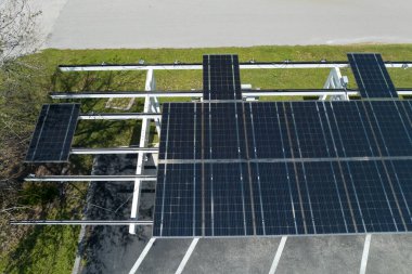 Park alanının gölgesinde, temiz enerjinin etkin üretimi için park etmiş arabaların güneş panellerine rüzgar hasarı.