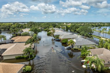 Debby Kasırgası, Sarasota, Florida 'da sokağı sular altında bıraktı. Yerleşim bölgelerindeki kırsal evlerin arasındaki sel sularında kayıkla gezen kurbanlar.
