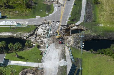 Florida 'da kasırga sonrası yıkılan köprünün tamiri. Su baskınından sonra hasarlı yolun yeniden inşası asfaltı yıkadı. Yol çalışması alanında inşaat ekipmanları.