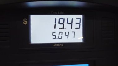 Benzin istasyonunda pahalı benzin var. Benzin pompası görüntüsü fiyatın hızla arttığını gösteriyor.