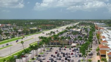 North Port, Florida 'da alışveriş merkezleri ve araba sürücüleri olan çok şeritli Amerikan yolu. ABD 'nin perakende ve ulaştırma altyapısının üzerinden görüntüle.