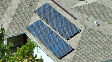 Banliyö bölgesinde temiz ekolojik elektrik üretimi için özel evin güneş çatısı fotovoltaik panellerle kaplı. Enerji tasarrufu için özerk eve yatırım yapma kavramı.