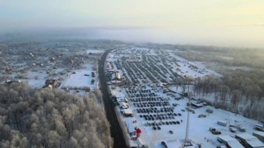 Satılık birçok arabanın hava manzarası ve kışın araba pazarında veya otoparkta yürüyen müşteriler..