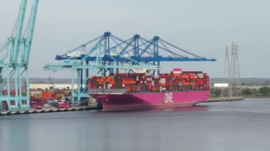 Georgia, Savannah 'daki deniz limanında kargo konteynırı. Crane nakliye konteynırlarını boşaltıyor. Uluslararası üretim malları sevkiyatı