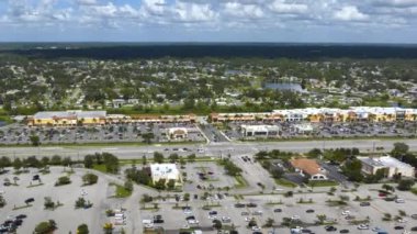 North Port, Florida 'daki American geniş yolu ve alışveriş merkezi plazası. Sürücü arabalı şehir trafiği. ABD ulaştırma altyapı kavramı