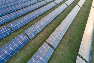 Temiz ekolojik elektrik enerjisi üretmek için sıra sıra güneş fotovoltaik panelleri olan sürdürülebilir büyük elektrik santralinin havadan görünüşü. Sıfır emisyon kavramı ile yenilenebilir elektrik.