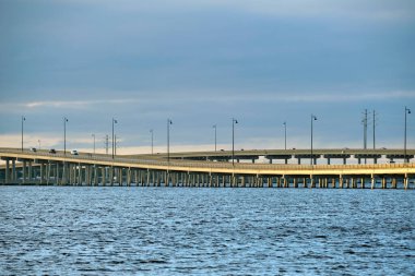 Barron Collier Bridge and Gilchrist Bridge in Florida with moving traffic. Transportation infrastructure in Charlotte County connecting Punta Gorda and Port Charlotte over Peace River.