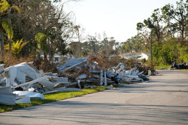 Florida gezici ev bölgesinde meydana gelen kasırgadan sonra ağır hasar gören evlerin yol kenarındaki çöp yığınları. Doğal afetin sonuçları..