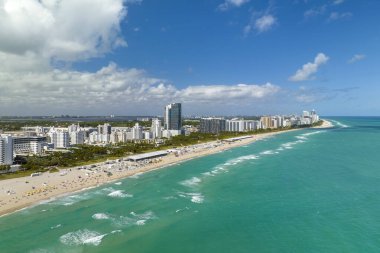 Güney Sahili 'nin kumlu yüzeyi. Sıcak Florida güneşinde dinlenen turistler. Güney Amerika 'da turizm altyapısı. Yüksek lüks otelleri ve apartmanları olan Miami Beach City..