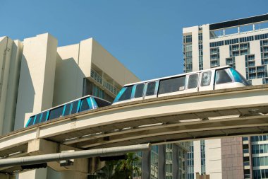 Florida ABD 'nin Miami Brickell şehrinde şehir içi taşımacılık. Modern Amerikan megapolis 'inde gökdelen binaları arasında yüksek demiryolu üzerindeki metro vagonu..