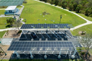 Park alanının gölgesinde, temiz enerjinin etkin üretimi için park etmiş arabaların güneş panellerine rüzgar hasarı.