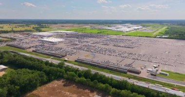 Kargo treni araba taşıyor. Satılık gıcır gıcır arabaları olan bir fabrika otoparkı. Amerikan otomotiv endüstrisinin gelişimi