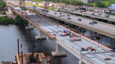 Otoyol köprüsü inşaatında çalışanlar. Tbridge 'in Manatee Nehri' ni geçişi. Hareket halindeki arabalı Amerikan otoyolu.