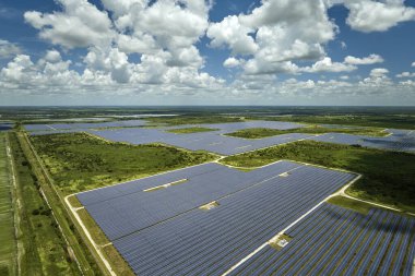 Temiz elektrik enerjisi üretmek için sıra sıra güneş fotovoltaik panelleri olan sürdürülebilir büyük elektrik santralinin havadan görünüşü. Sıfır emisyonlu yenilenebilir elektrik kavramı.