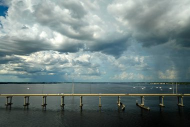 Barron Collier Bridge and Gilchrist Bridge in Florida with moving traffic. Transportation infrastructure in Charlotte County connecting Punta Gorda and Port Charlotte over Peace River. clipart