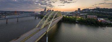 Ohio, Cincinnati 'de trafik Daniel Carter Sakal Köprüsü' nde şehir merkezindeki yüksek gökdelen binalarıyla aydınlandı. Geceleri finans bölgesi olan bir Amerikan şehri..