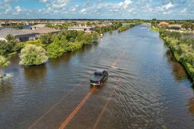 Kasırga yağmuru yolu sular altında bıraktı. Florida yerleşim bölgesinde, şehir caddesinde boğulmuş bir araba. Kasırga doğal felaketinin sonuçları..