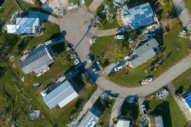 Hurricane strong wind destroyed suburban house roofs in Florida mobile home residential area. Consequences of natural disaster. clipart