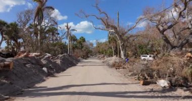 Doğal afetin sonuçları. Milton Kasırgası dalgalanmasından sonra ciddi hasar gören evlerin çöpleri. Florida 'da Manasota Key Caddesi' nde enkaz yığınları var.