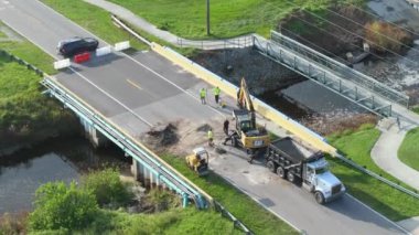 Yol yapımı. Florida 'daki asfaltı sel baskınından sonra yıkılan köprüyü onaran işçiler. Yol çalışması alanında inşaat ekipmanları