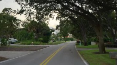 Venice, Florida yerleşim bölgesinde özel evler arasında Amerikan banliyö caddesinde araba sürüyor.