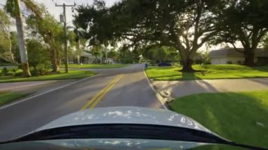 Araba bakış açısı. Venice Florida kırsal kesimindeki konutlar arasında banliyö sokağında araba sürüyor. Ulaşım ve trafik kavramı