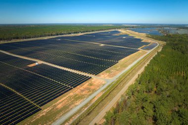 Temiz elektrik enerjisi üretmek için birçok sıra güneş fotovoltaik paneli bulunan sürdürülebilir büyük elektrik santralinin havadan görünüşü. Sıfır emisyon kavramı ile yenilenebilir elektrik.