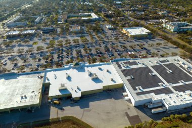 Bir marketin önündeki otoparkta park edilmiş birçok arabanın hava görüntüsü..