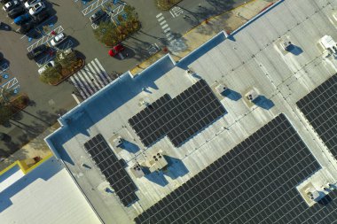 Electric photovoltaic solar panels installed on shopping mall building rooftop for production of green ecological electricity. Concept of producing sustainable energy. clipart