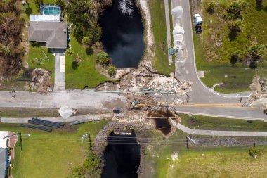 Florida 'da kasırga sonrası yıkılan köprünün tamiri. Su baskınından sonra hasarlı yolun yeniden inşası asfaltı yıkadı. Yol çalışması alanında inşaat ekipmanları.
