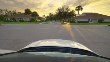 Araba sürücüsü. Ulaşım ve trafik kavramı. Florida yerleşim bölgesindeki evler arasında banliyö caddesinde araç sürüyor.