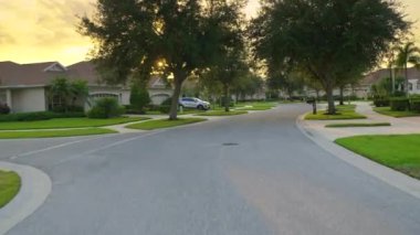 Araba sürücüsü. Ulaşım ve trafik kavramı. Florida yerleşim bölgesindeki evler arasında banliyö caddesinde araç sürüyor.