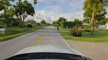 Posta arabası ABD 'de şehir caddesinde sürüyor. Venice, Florida yerleşim bölgesindeki özel evler arasında Amerikan banliyösü