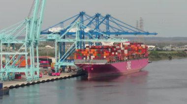 Savannah, Georgia 'da kargo konteynırları olan konteynır limanı. Crane nakliye konteynırlarını boşaltıyor. Üretilen malların uluslararası deniz sevkiyatı