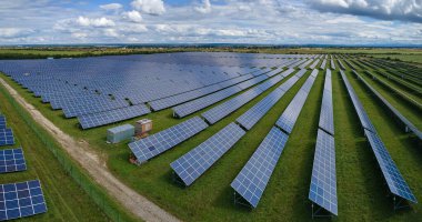 Temiz elektrik enerjisi üretmek için birçok sıra güneş fotovoltaik paneli bulunan sürdürülebilir büyük elektrik santralinin havadan görünüşü. Sıfır emisyon kavramı ile yenilenebilir elektrik.