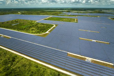 Temiz elektrik enerjisi üretmek için birçok sıra güneş fotovoltaik paneli bulunan sürdürülebilir büyük elektrik santralinin havadan görünüşü. Sıfır emisyon kavramı ile yenilenebilir elektrik.