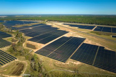 Temiz elektrik enerjisi üretmek için birçok sıra güneş fotovoltaik paneli bulunan sürdürülebilir büyük elektrik santralinin havadan görünüşü. Sıfır emisyon kavramı ile yenilenebilir elektrik.