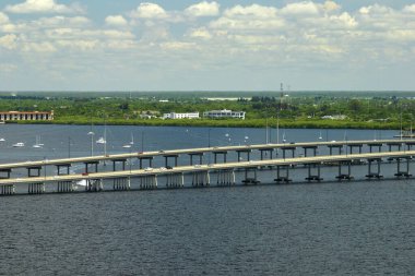Barron Collier Bridge and Gilchrist Bridge in Florida with moving traffic. Transportation infrastructure in Charlotte County connecting Punta Gorda and Port Charlotte over Peace River.