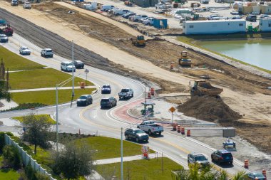 Kavşakta inşaat halindeki trafik arabalarını sürüyorlar. Amerikan yolunda hareket eden arabalarla trafik çemberi inşa etmek.