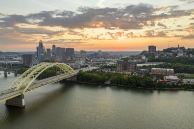Ohio, Cincinnati 'de trafik Daniel Carter Sakal Köprüsü' nde şehir merkezindeki yüksek gökdelen binalarıyla aydınlandı. Gün batımında finans bölgesi olan Amerikan şehri.