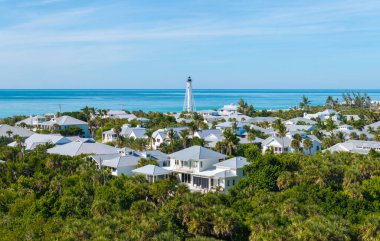 Large residential homes and tall lighthouse in island small town Boca Grande on Gasparilla Island in southwest Florida. American waterfront houses in rural US suburbs. clipart